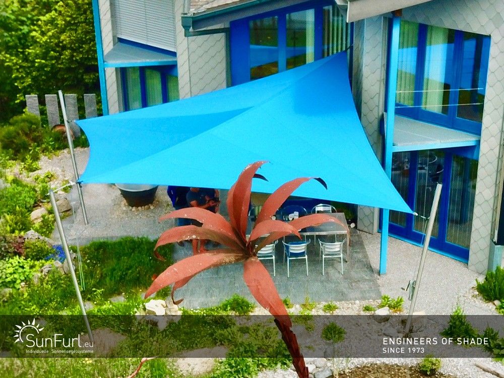 Blauer Sonnenschutz über Terrassentisch